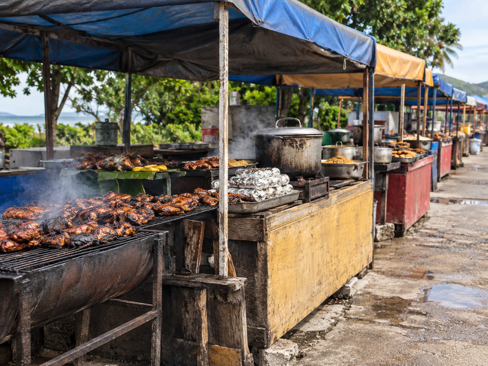 Rows of covered food stalls with grills and steaming pots in daylight