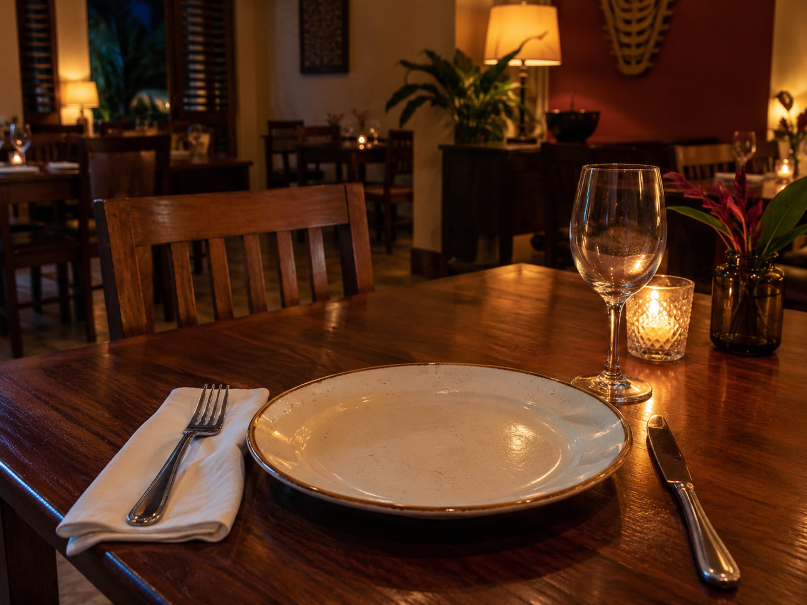 A single set table in a softly lit dining room in the evening