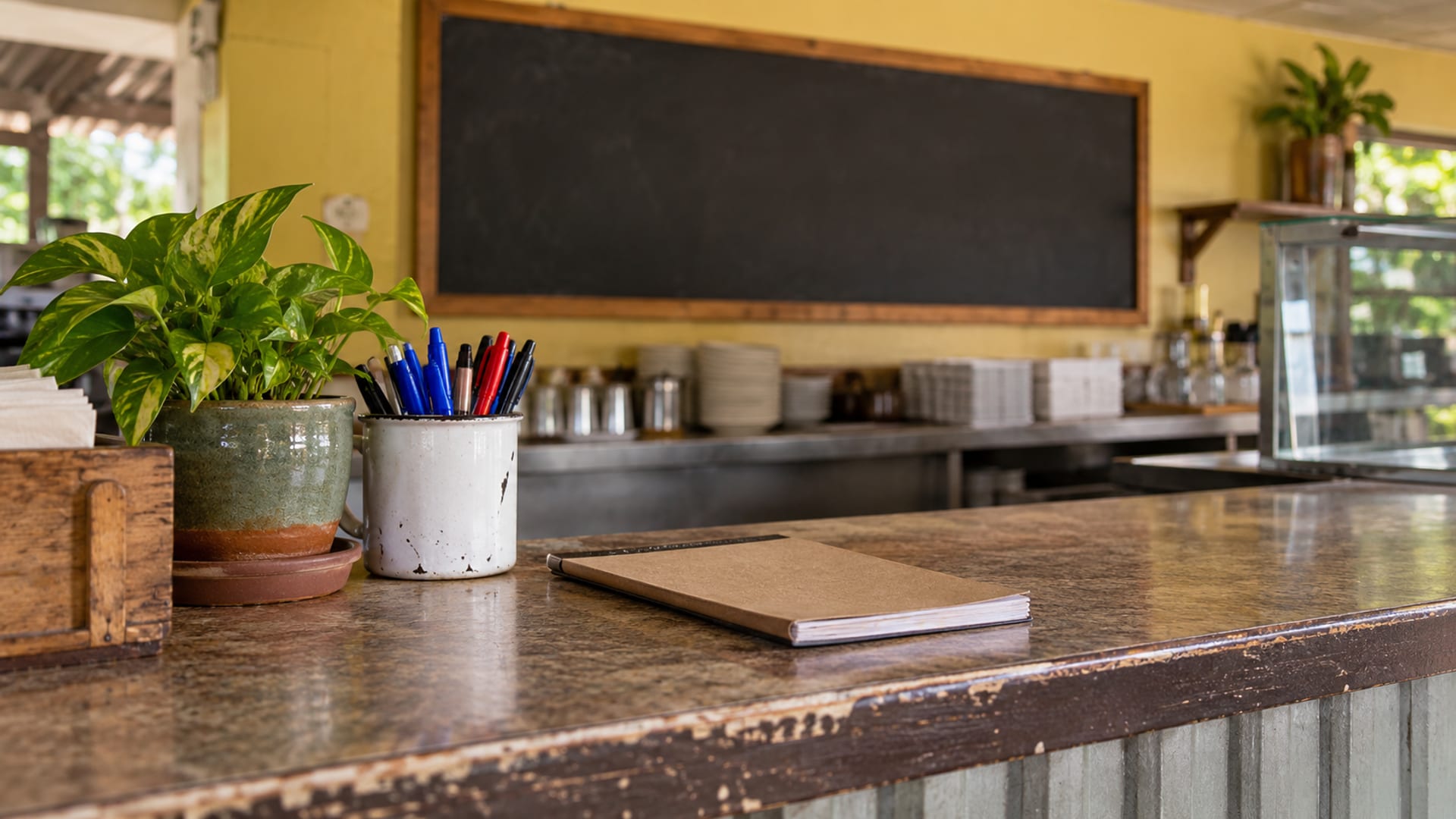 A tidy restaurant front counter with a closed order pad